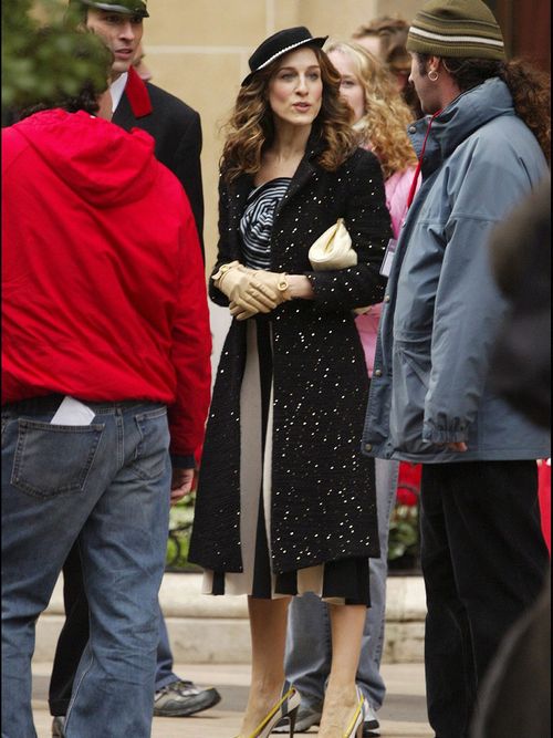 Sarah Jessica Parker in einem schwarz gepunkten Mantel und einem kleinen Hut.