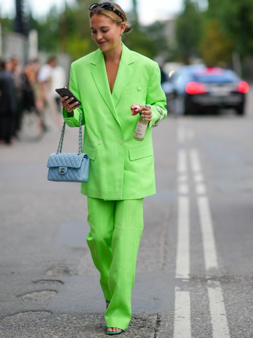 Street Style Look von der Copenhagen Fashion Week wo ein Gast einen grünen Leinen Anzug mit einer blauen Chanel Tasche trägt.