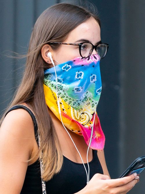 Eine Frau in New York verwendet ein buntes Bandana-Tuch als Mundschutz.