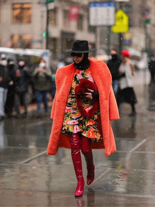 Moderedakteurin Denisa Palsha trägt glänzende Stiefel im roten All-Over-Look