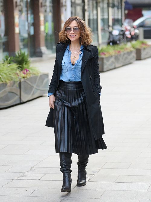 Streetstyle mit einem Jeanshemd, einem plissierten Lederrock und schwarzen Stiefeln.