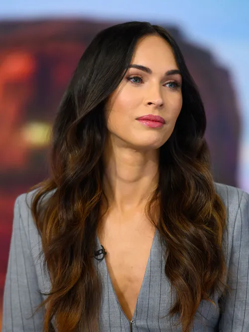 Meghan Fox mit leicht gewellten Haaren die sie zu einem Mittelscheitel trägt.