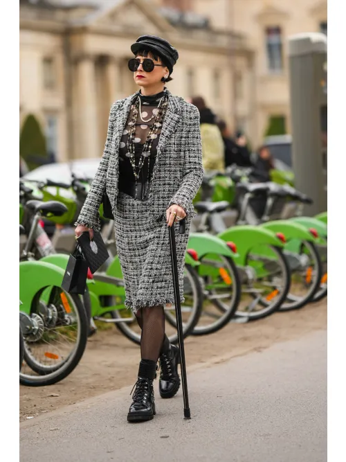 A guest wearsblack shiny leather laces block heels ankle boots outside Chanel, during Paris Fashion Week - Womenswear Fall Winter 2023 2024