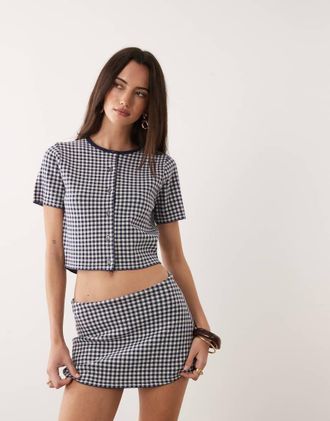 Good American Top a maniche corte con scollo rotondo e chiusura con bottoni in maglia sottile blu navy a quadretti in coordinato