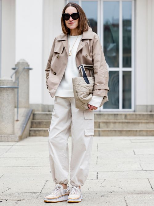 Netti Weber trägt eine Cargohose in Beige mit Hoodie und kurzgeschnittener Trenchjacke in München