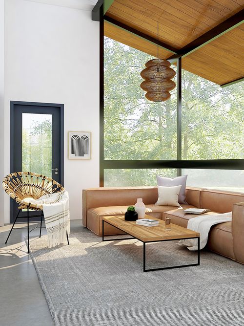 Wohnzimmer mit großer Fensterfront einem braunen Ledersofa und einem Couchtisch aus Holz.