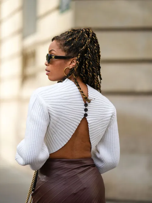 Ellie Delphin wears a white backless sweater