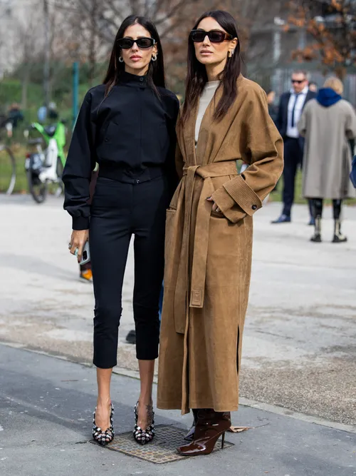 Gilda Ambrosio wears black cropped pants, jacket, heels & Giorgia Tordini wears brown wild leather coat, boots outside Ferragamo during the Milan Fashion Week - Womenswear Fall/Winter 2024-2025 on February 24, 2024 in Milan, Italy.
