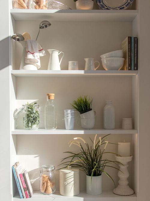 Offenes Küchenregal in Weiß mit Küchenutensilien.