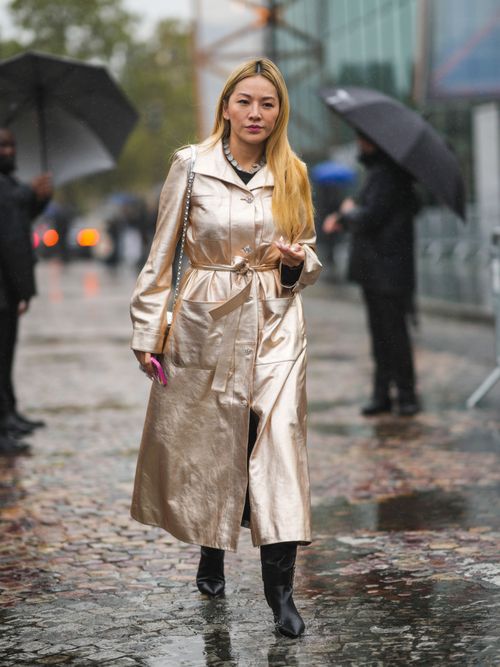Tina Leung trägt einen metallicfarbenen Mantel und schwarze Stiefel auf der Paris Fashion Week.