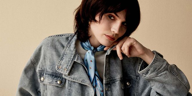 Frau mit einer Jeansjacke und einem hellblauen Halstuch