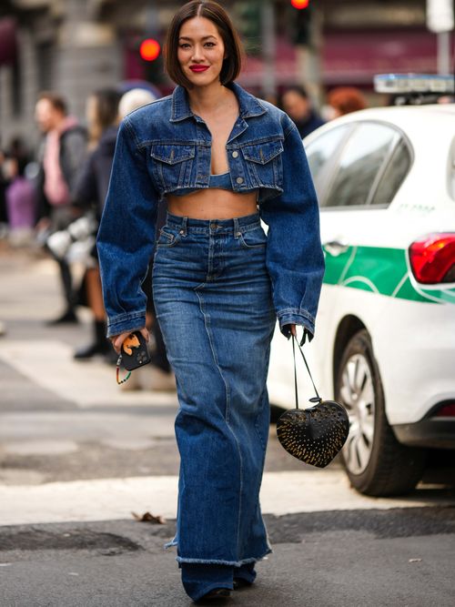 Tiffany Hsu trägt eine kurzgeschnittene Jeansjacke im Bomberschnitt mit einem langen Denimrock auf der Milan Fashion Week.