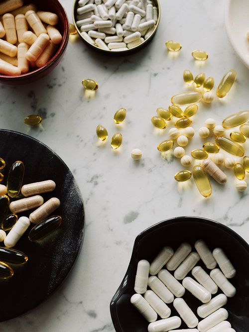 Ein Marmortisch auf dem viel kleine schwarze Schüssel mit Nahrungsergänzungsmittel sind.