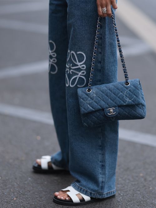 Street Style Close-up, wo man eine Jeans von Loewe, Sandalen von Hermes und eine Chanel Tasche sieht.