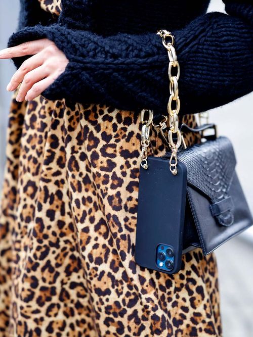 Close up von eine Leoprin-Rock und einer schwarzen Tasche und einem goldenen Phone Charm.