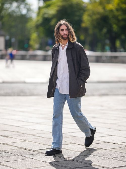 Streetstyle mit einem Mann mit mittellangen lockigen Haaren und einer Jeans.