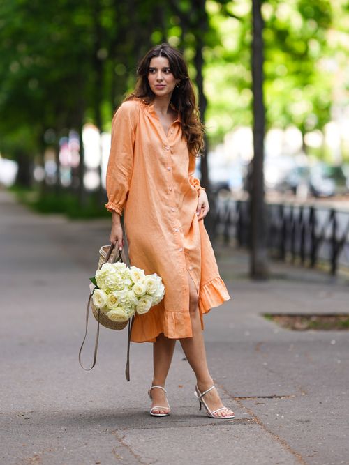 Ketevan Giorgadze trägt ein orangefarbenes Kleid aus Leinen mit einer Korbtasche in Paris.