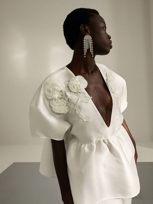 Frau in Brautoberteil mit einem großen Strassohrring.