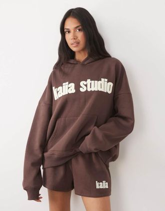 KAIIA Studio - Felpa con cappuccio oversize in misto cotone marrone e giallo con logo ricamato in coordinato