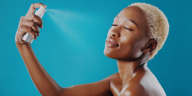 Schwarze Frau mit blondem Buzzcut trägt ein Setting Spray auf