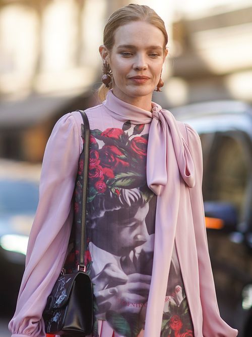 Model Natalia Vodianova in einem rosa Top mit großer Schluppe.