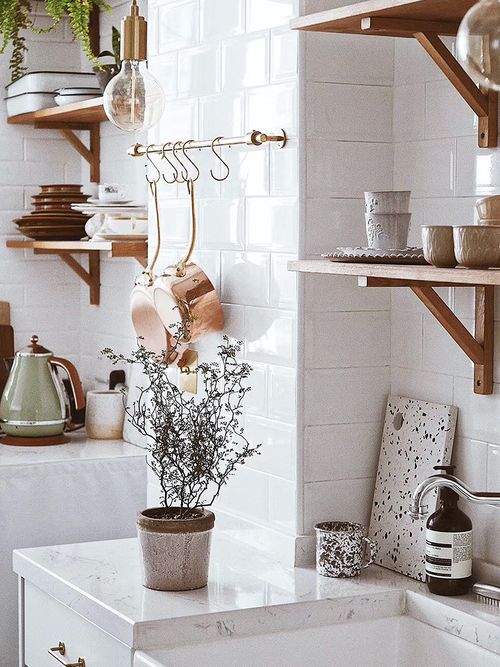 Close up einer weißen Küche mit Holzregalen.