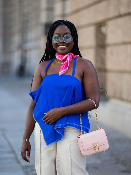 Lois Opoku stylt zu ihrem knallblauen Top eine pinkes Halstuch.