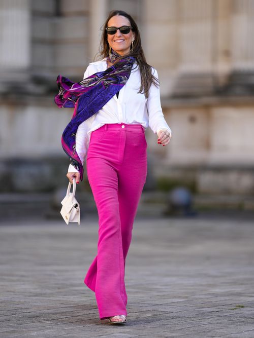 Alba Garavito Torre trägt eine Pinke High Waist Jeans mit einer weißen Bluse und langem Tuch