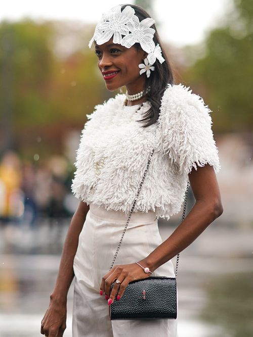 Frau mit Federtop, Fascinator und Perlenchocker.