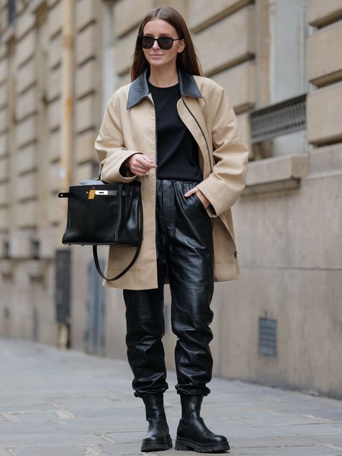 Diane Batoukina trägt einen beigen Mantel mit schwarzem T-Shirt und Lederhose mit Combat Boots in Paris.