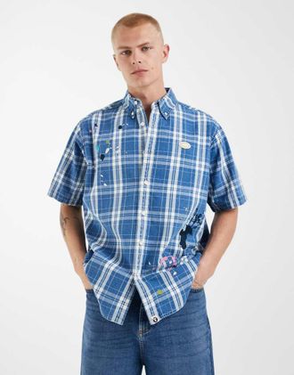Aape By A Bathing Ape Aape by A Bathing Ape - Camicia a maniche corte blu e bianca a quadri con spruzzi sul fondo-Multicolore