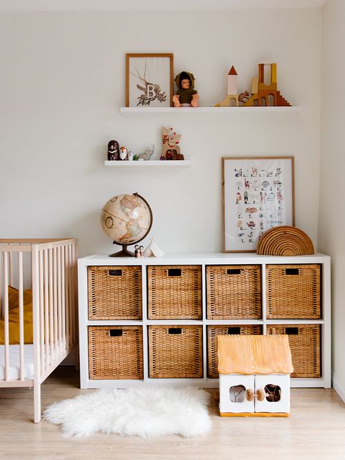 Kinderzimmer mit Gitterbett, Ikea Kallax Regal und Körben.