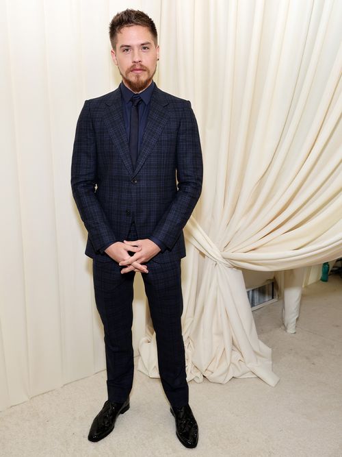 Dylan Sprouse in einem blau karierten Anzug.