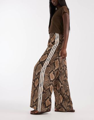 adidas Originals pantaloni sportivi in raso a gamba larga con stampa snake marrone chiaro-Neutro
