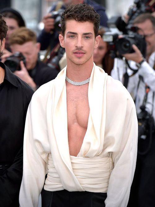 Manuel Rios wears a flowing white blouse and a silver necklace