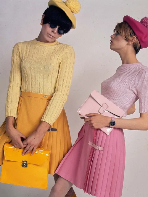 Zwei Modesl aus den 1960ern mit einem Minirock, Baskenmütze und Pullover.