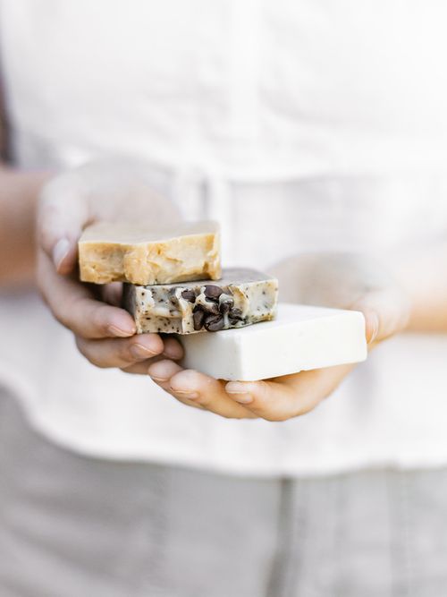 Frauenhände halten 3 Stück Seife in der Hand.