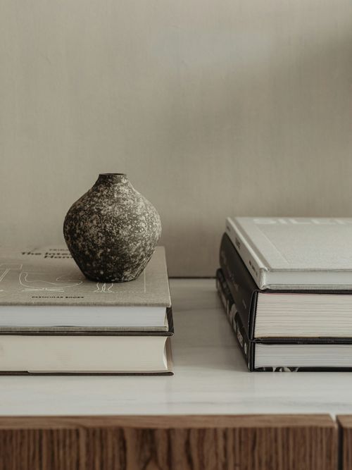 Foto von Coffee Table Books und einer Vase in grauen und braunen Erdtönen.