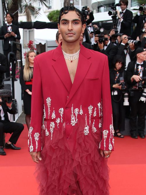 Rahi Chadda wears a red suit with jewels.