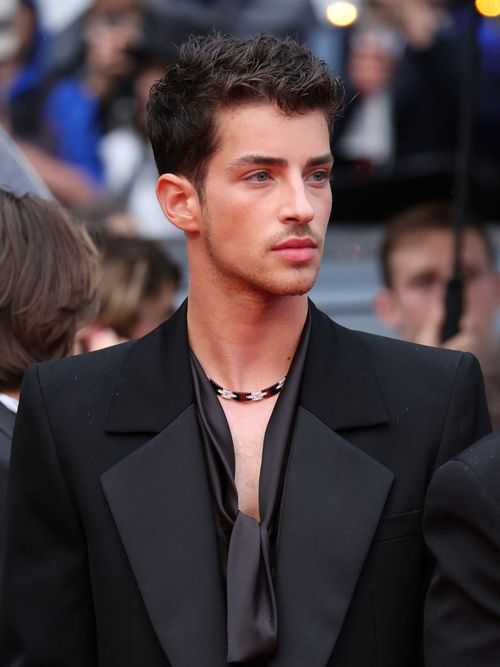 Manuel Rios wears a black tux with delicate necklace