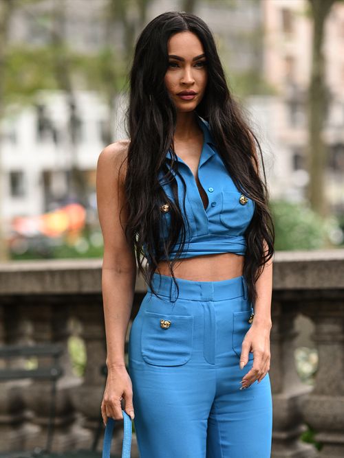 Meghan Foy in einem blauen Zweiteiler und langen gewellten Haaren.