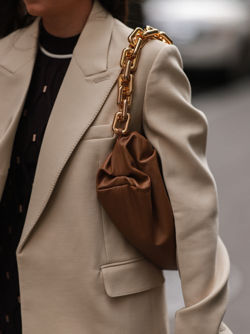 Detailaufnahme von einem Street Style Look mit einer Puffy Tasche die Chunky Ketten als Statement Henkel haben.