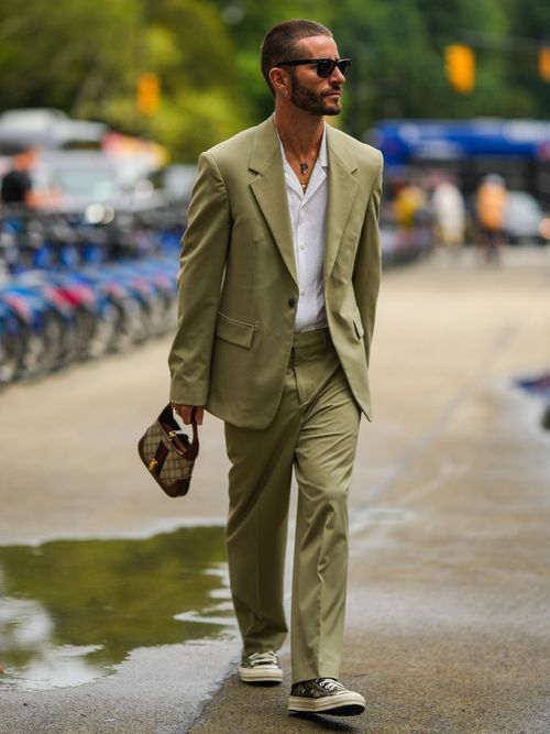 Pelayo Diaz trägt einen grünen Anzug mit weißem Hemd, Sonnenbrille und Gucci Tasche auf der New York Fashion Week.