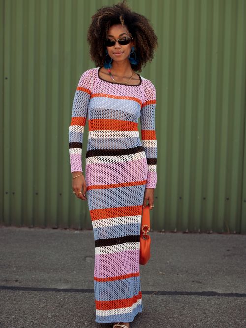Amaka Hamelijnck trägt ein langes Strickkleid in bunten Farben auf der Copenhagen Fashion Week.