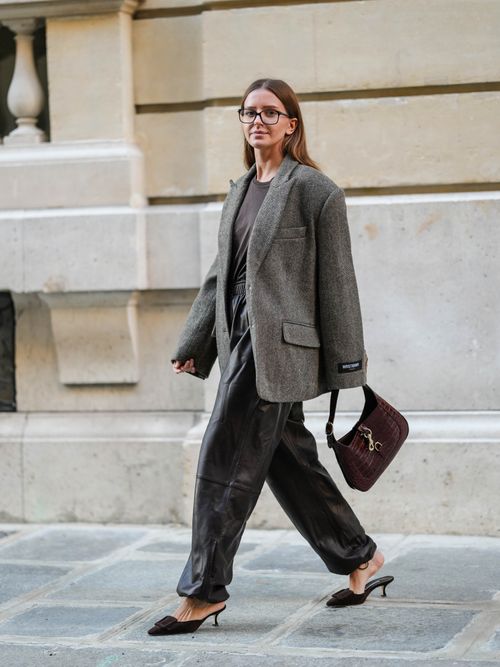 Diane Batoukina trägt einen oversized Blazer mit schwarzer Lederhose, YSL-Tasche und Kitten Heels in Paris