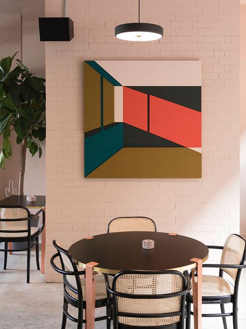 Ausschnitt einer Sitzgruppe aus Wiener Geflecht vor einem modernen Bild.