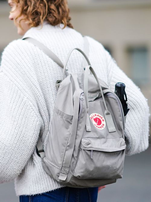 Streetstyle mit einer weißen Strickjacke und einem grauen Rucksack