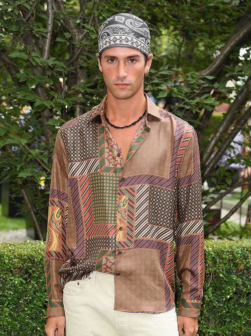 Mann mit einem Bandana als Kopftuch und einem braunen Hemd in Patchwork-Optik.