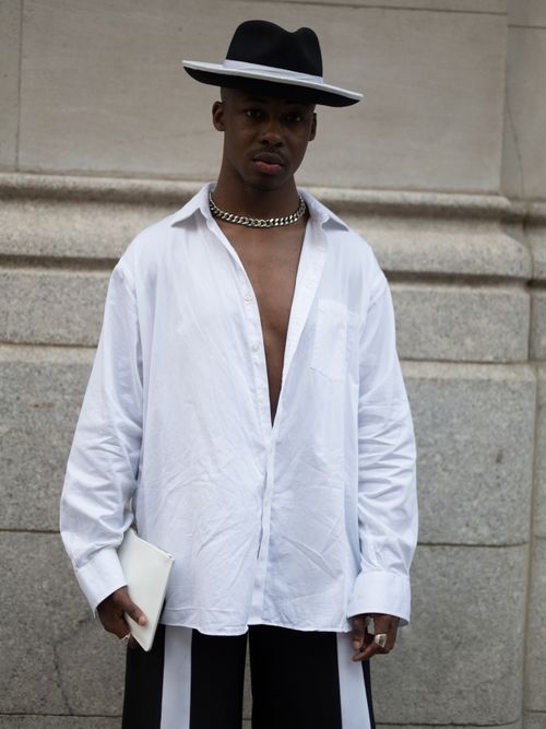 Elijah Boothe trägt ein weißes Hemd mit Kette und Hut auf der New York Fashion Week.