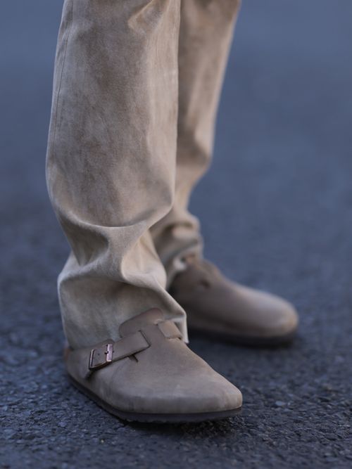 Close-up von einem Boston Clog Birkenstock Schuh in Grau mit einer beigen Jeanshose.